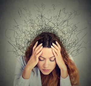 Stressed woman holding head in her hands