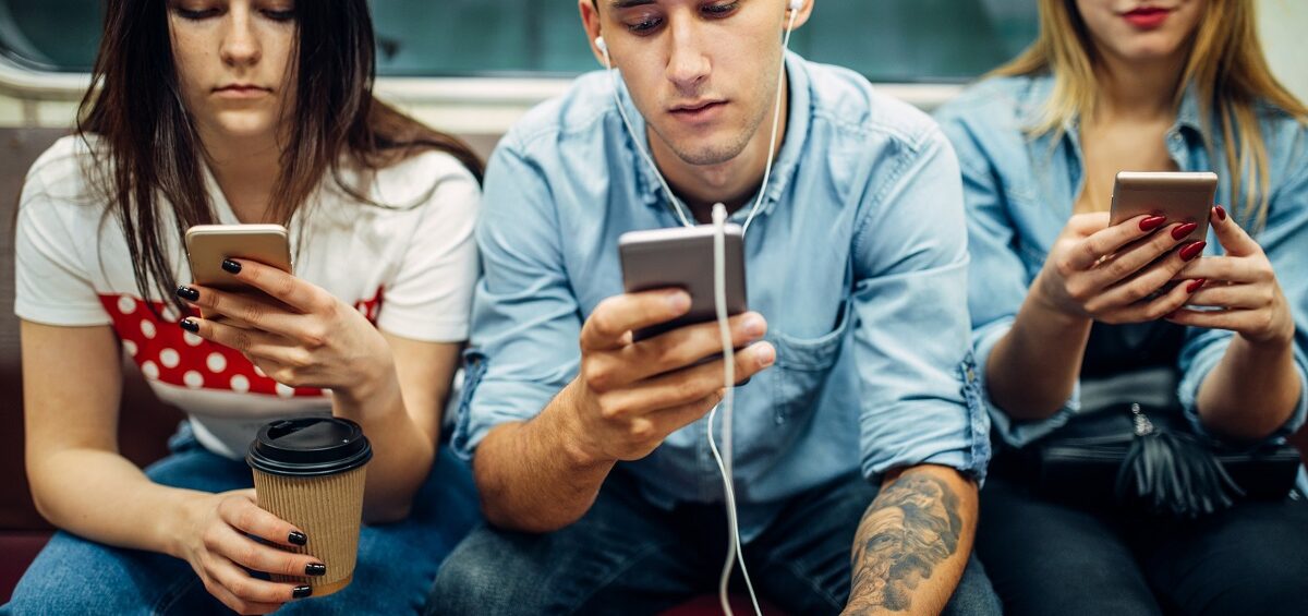 Modern youth using phones in subway, addiction