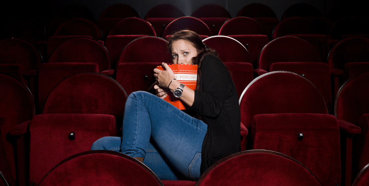 Image of a fearful woman in a movie theater